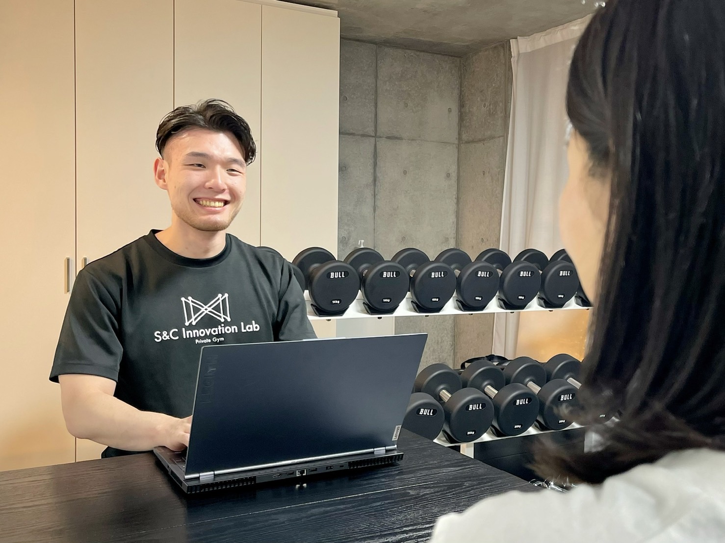 トレーナーがクライアントとカウンセリングを行う様子